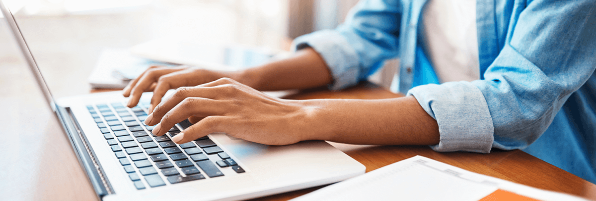 close up of hands typing on a laptop